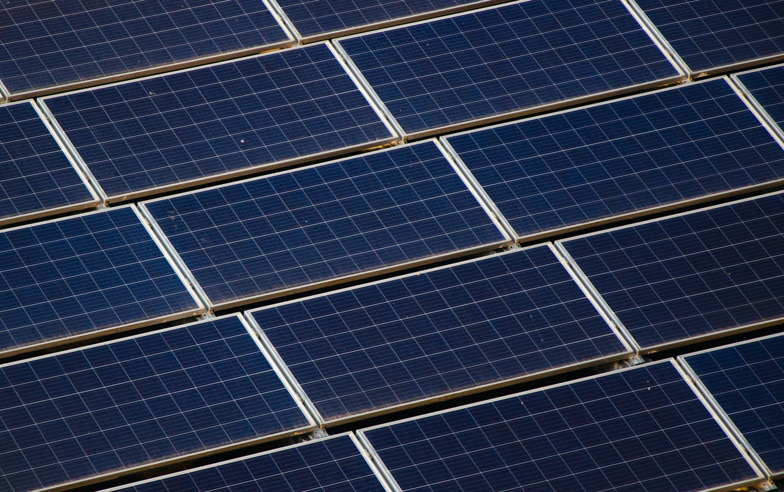 Illustrationsfoto: Photovoltaikmodule auf einem Gebäudedach, von oben aufgenommen.